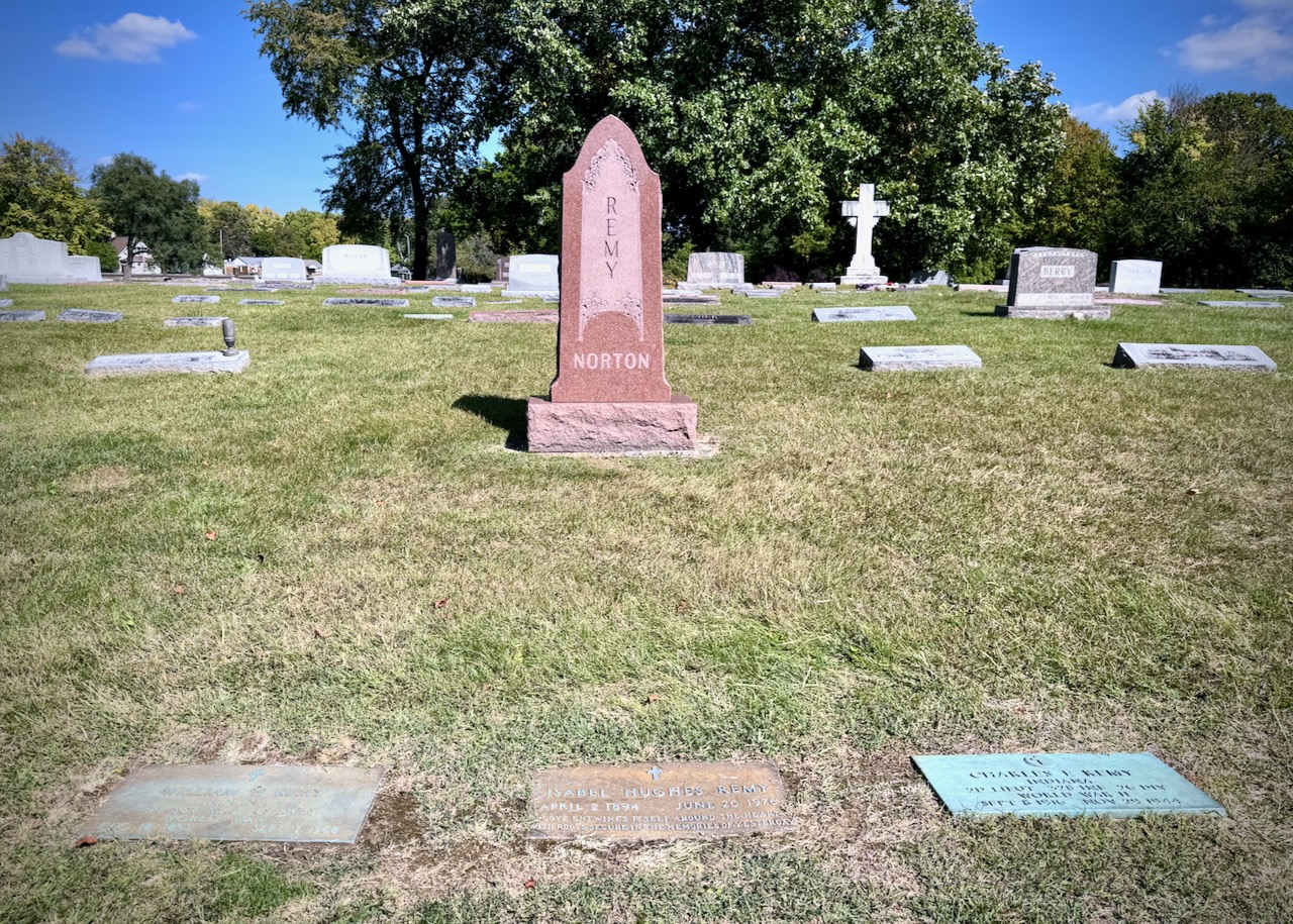 Picture of cemetery with one upright headstone with the name REMY going down the middle. Under that it says NORTON. There are three footstones for William H. Remy (husband), Isabel Hughes Remy (wife), and Charles E. Remy (son).